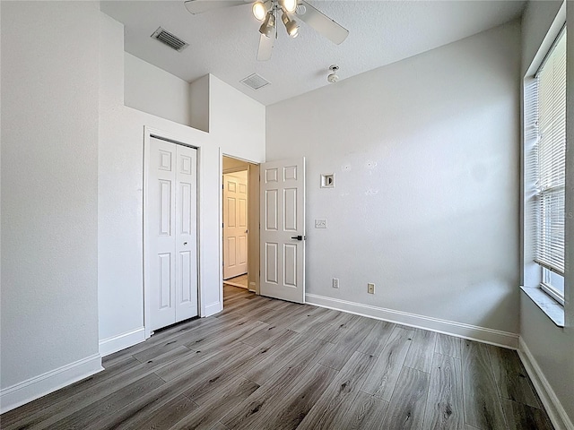 2421 Cimmaron Ash Way, Apopka, FL 32703 - unfurnished bedroom with wood finished floors, a closet, ceiling fan, and lofted ceiling