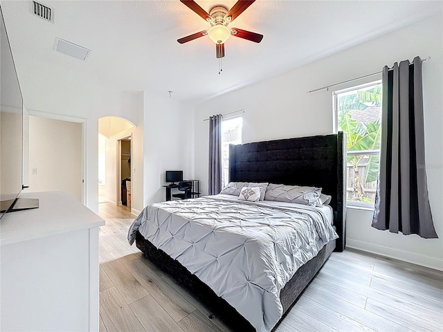 2421 Cimmaron Ash Way, Apopka, FL 32703 - bedroom featuring arched walkways, light wood-style flooring, and ceiling fan