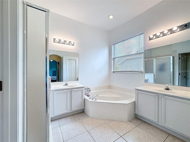 2421 Cimmaron Ash Way, Apopka, FL 32703 - bathroom featuring a shower stall, a garden tub, tile patterned floors, and two vanities