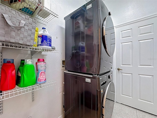 2421 Cimmaron Ash Way, Apopka, FL 32703 - washroom with stacked washing machine and dryer, a textured wall, and tile patterned floors