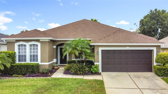 2421 Cimmaron Ash Way, Apopka, FL 32703 - view of front facade featuring stucco siding, driveway, an attached garage, a front lawn, and roof with shingles