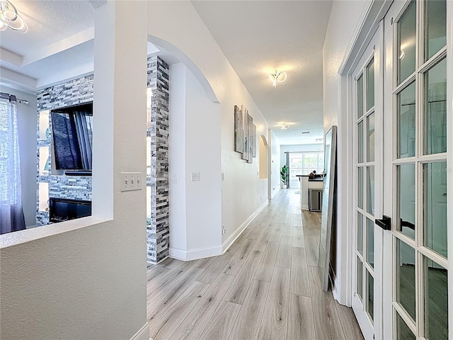 2421 Cimmaron Ash Way, Apopka, FL 32703 - corridor featuring light wood-type flooring, arched walkways, and french doors