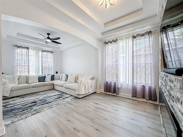 2421 Cimmaron Ash Way, Apopka, FL 32703 - living area with a raised ceiling, light wood-type flooring, arched walkways, and a ceiling fan
