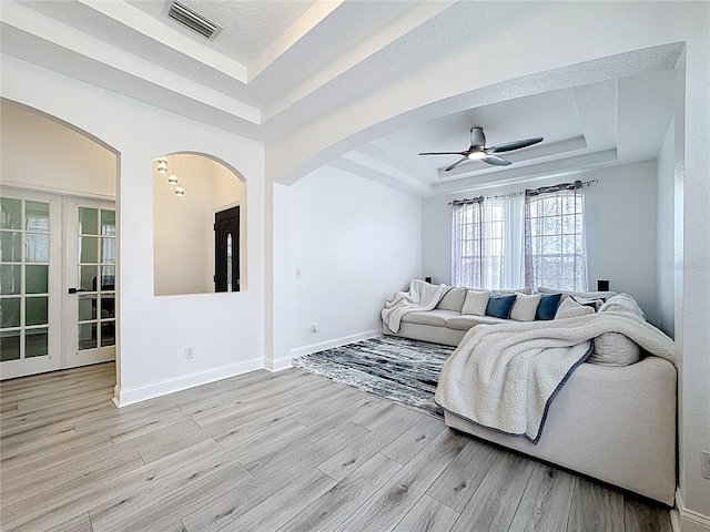 2421 Cimmaron Ash Way, Apopka, FL 32703 - living area with a tray ceiling, light wood-type flooring, and arched walkways
