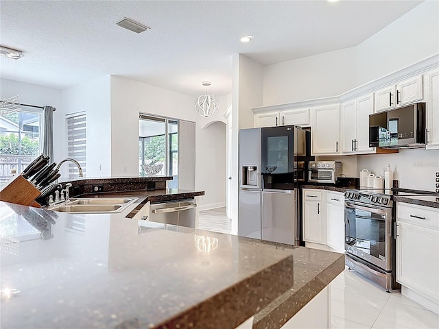 2421 Cimmaron Ash Way, Apopka, FL 32703 - kitchen featuring appliances with stainless steel finishes, healthy amount of natural light, arched walkways, white cabinets, and recessed lighting