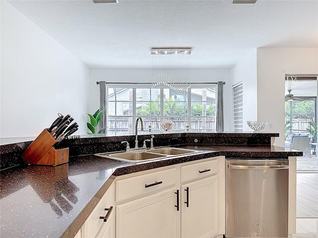 2421 Cimmaron Ash Way, Apopka, FL 32703 - kitchen with stainless steel dishwasher, white cabinetry, and a textured ceiling