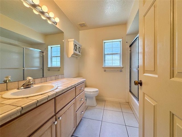14933 Thoroughbred Ln, Montverde, FL 34756 - full bathroom with vanity, plenty of natural light, tile patterned flooring, combined bath / shower with glass door, and a textured ceiling