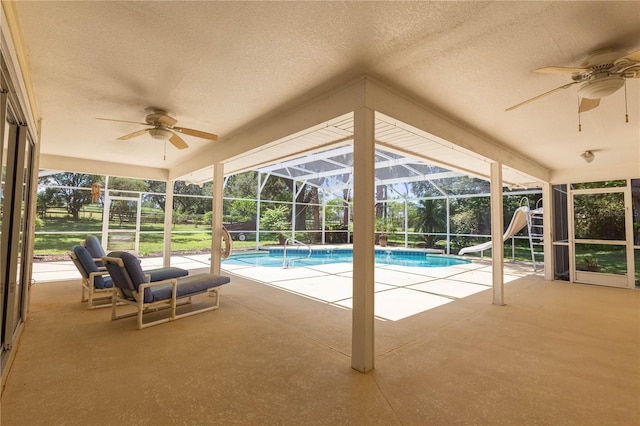 14933 Thoroughbred Ln, Montverde, FL 34756 - swimming pool featuring a ceiling fan, a water slide, a patio, and glass enclosure