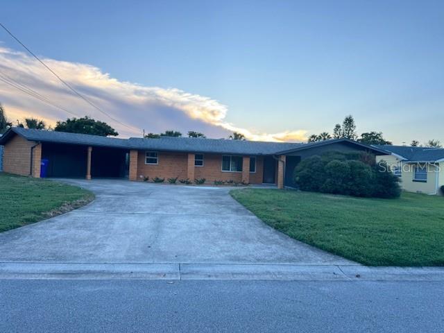 1503 Canal Ct, Tavares, FL 32778 - single story home with driveway, a yard, an attached carport, and brick siding