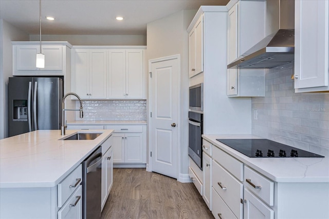 111 Bottle Brush Dr, Haines City, FL 33844 - kitchen with black appliances, wall chimney range hood, decorative backsplash, light wood-style flooring, and white cabinetry