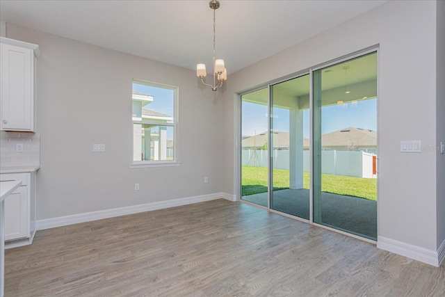 111 Bottle Brush Dr, Haines City, FL 33844 - unfurnished dining area featuring light wood-style floors and a chandelier