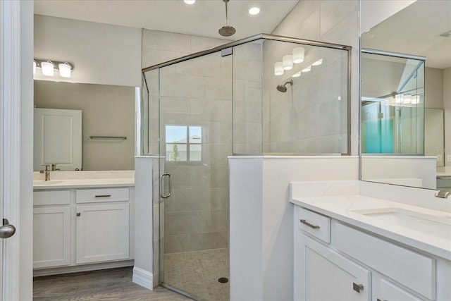 111 Bottle Brush Dr, Haines City, FL 33844 - full bath featuring a stall shower, two vanities, recessed lighting, and wood finished floors