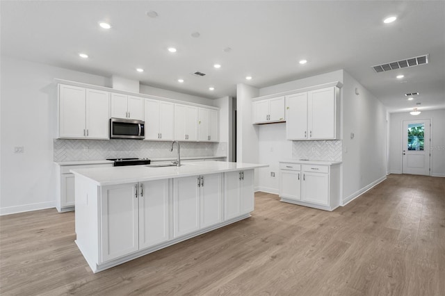 991 Fiesta Key Cir, Lady Lake, FL 32159 - kitchen with stainless steel microwave, white cabinets, and recessed lighting