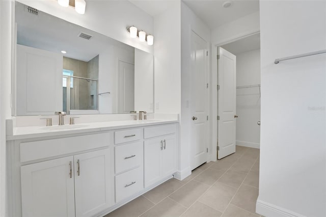 991 Fiesta Key Cir, Lady Lake, FL 32159 - bathroom with a stall shower, double vanity, tile patterned flooring, and a walk in closet