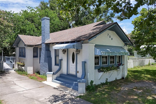 709 Daphne Ave, Umatilla, FL 32784 - view of front of home featuring a chimney, roof with shingles, and stucco siding