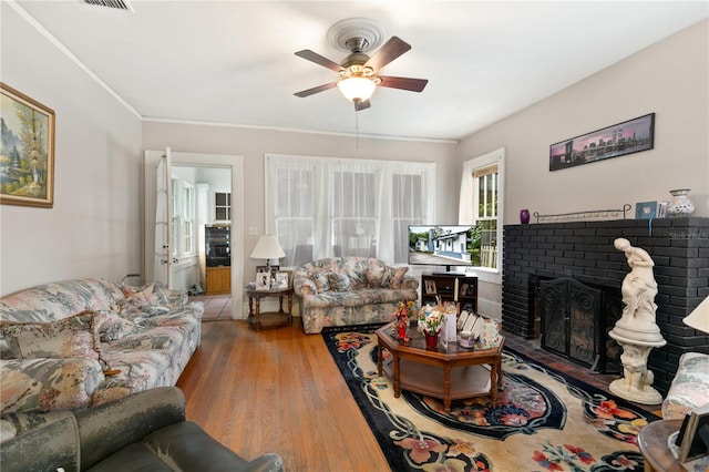 709 Daphne Ave, Umatilla, FL 32784 - living area featuring a ceiling fan, a brick fireplace, wood finished floors, and ornamental molding