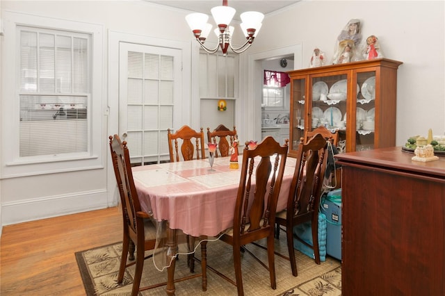 709 Daphne Ave, Umatilla, FL 32784 - dining space with a chandelier, crown molding, and light wood-style flooring