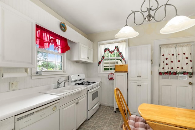 709 Daphne Ave, Umatilla, FL 32784 - kitchen featuring white appliances, white cabinets, light countertops, and hanging light fixtures
