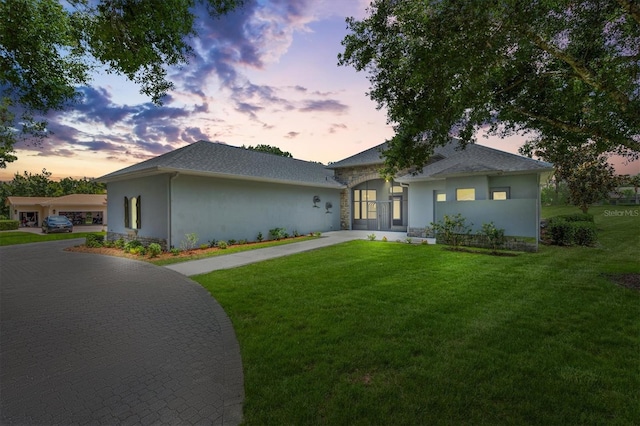 6109 Spinnaker Loop, Lady Lake, FL 32159 - ranch-style house with a yard, driveway, stucco siding, stone siding, and roof with shingles