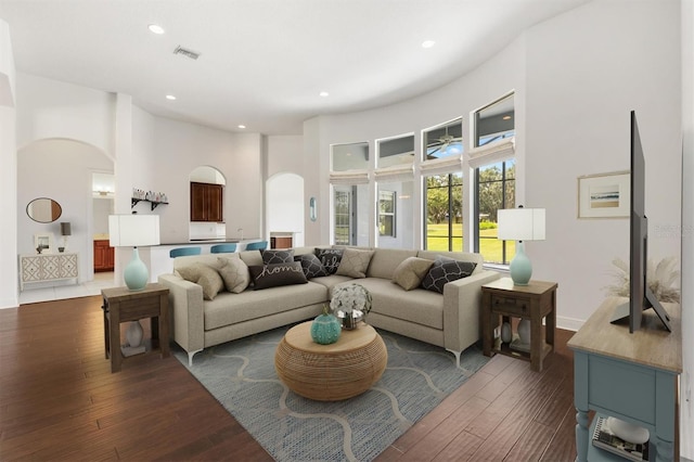 6109 Spinnaker Loop, Lady Lake, FL 32159 - living area with arched walkways, dark wood-style floors, a towering ceiling, and recessed lighting