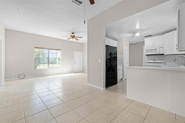 4751 Deer Run Rd, Saint Cloud, FL 34772 - kitchen with white microwave, ceiling fan, range, black fridge, and light tile patterned flooring
