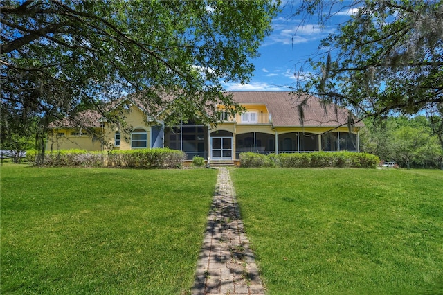 view of front facade featuring a front lawn and a sunroom