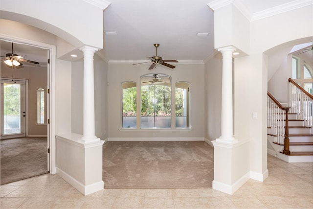 foyer with ornate columns, ceiling fan, and light carpet