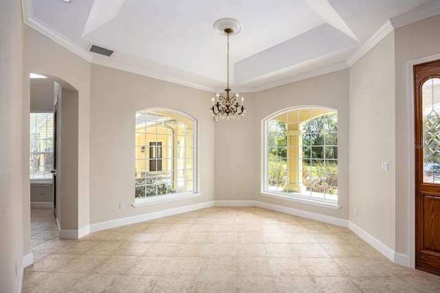 tiled spare room with a wealth of natural light, a raised ceiling, and a chandelier