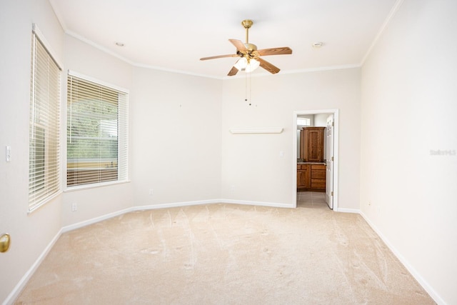 unfurnished room featuring light colored carpet, ceiling fan, and ornamental molding