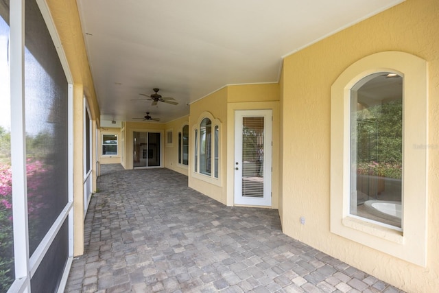 unfurnished sunroom with a healthy amount of sunlight and ceiling fan