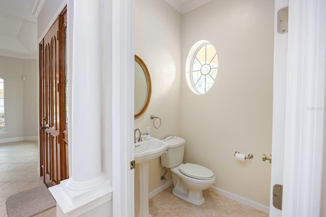 bathroom featuring a wealth of natural light, toilet, tile floors, and ornate columns