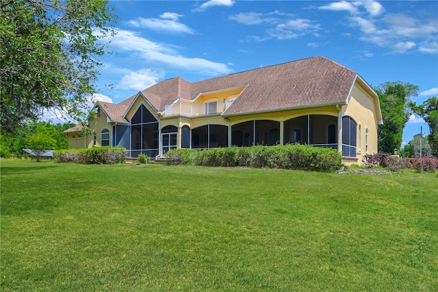 rear view of house with a sunroom and a lawn