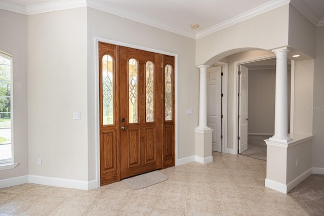 tiled foyer entrance with plenty of natural light, decorative columns, and crown molding