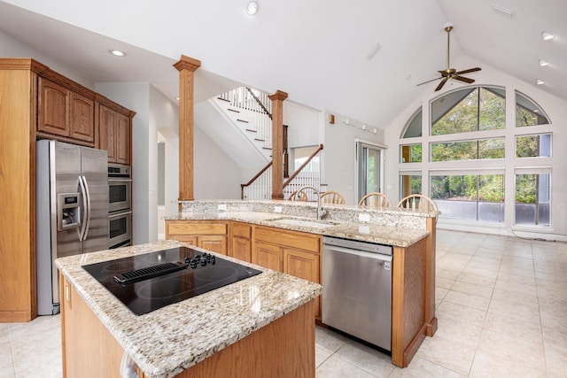 kitchen featuring sink, stainless steel appliances, a center island with sink, and light tile flooring