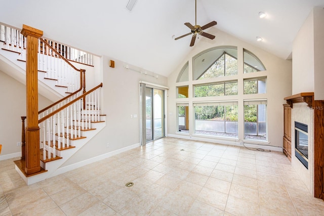 unfurnished living room featuring a healthy amount of sunlight, a fireplace, high vaulted ceiling, and ceiling fan