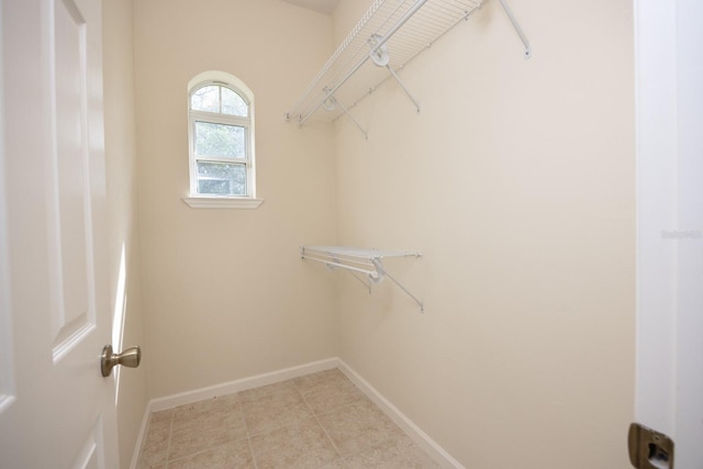 walk in closet with tile flooring