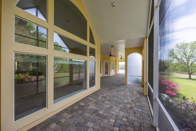 unfurnished sunroom featuring ceiling fan