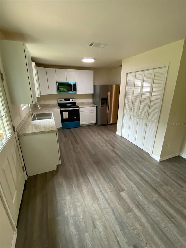 kitchen with white cabinetry, dark wood-type flooring, appliances with stainless steel finishes, and sink