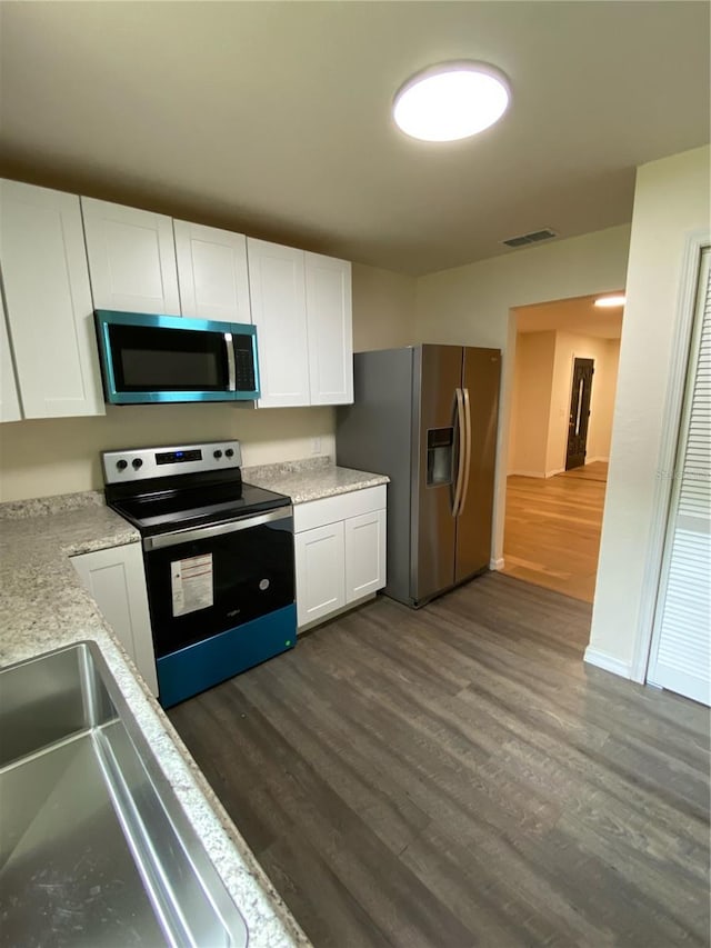 kitchen with white cabinetry, dark hardwood / wood-style floors, and stainless steel appliances