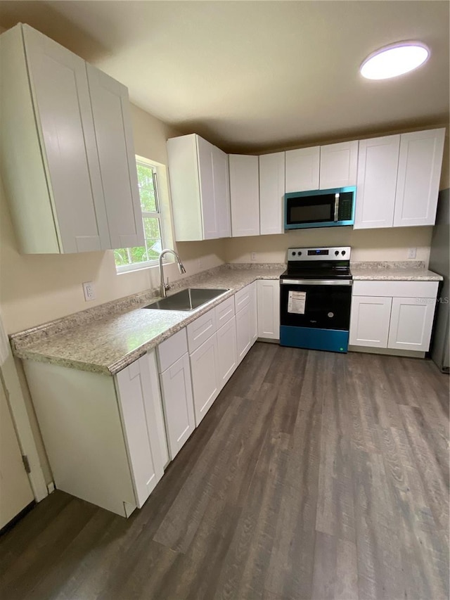 kitchen featuring appliances with stainless steel finishes, dark hardwood / wood-style flooring, white cabinetry, and sink