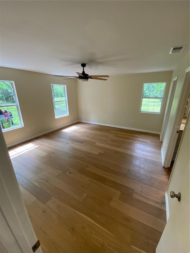 empty room with wood-type flooring and a healthy amount of sunlight