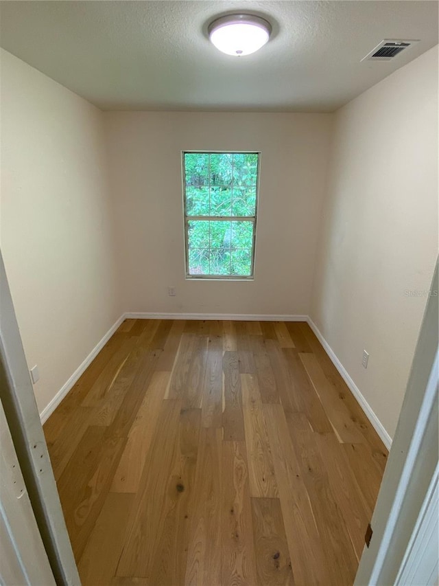 spare room with hardwood / wood-style floors and a textured ceiling