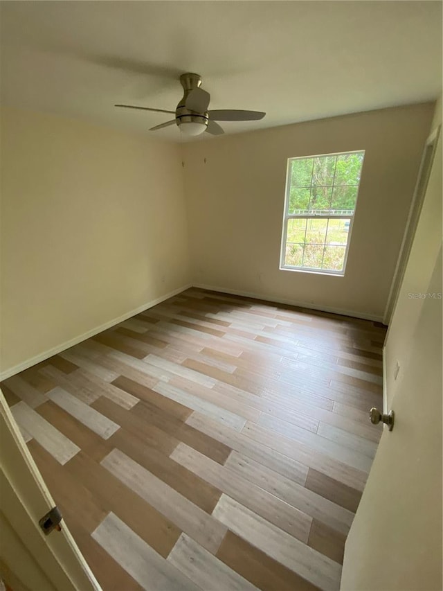 empty room with ceiling fan and light wood-type flooring