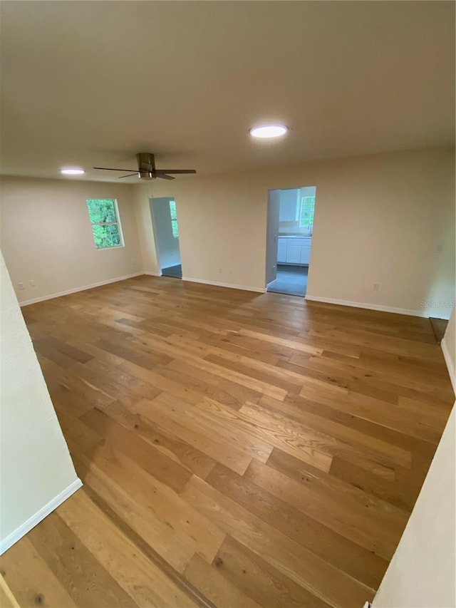 unfurnished room featuring plenty of natural light, light wood-type flooring, and ceiling fan