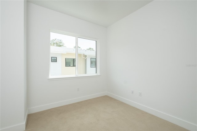 spare room featuring light colored carpet