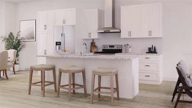 kitchen with white cabinetry, wall chimney exhaust hood, a kitchen island with sink, and appliances with stainless steel finishes