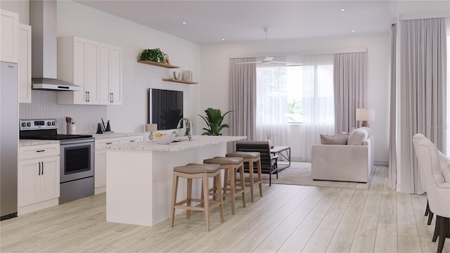 kitchen featuring light hardwood / wood-style floors, white cabinetry, a kitchen island with sink, and appliances with stainless steel finishes