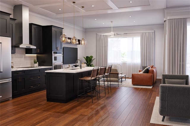 kitchen with sink, dark hardwood / wood-style floors, an island with sink, a breakfast bar, and appliances with stainless steel finishes