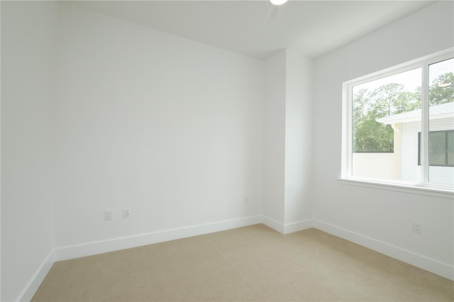 unfurnished room featuring light carpet