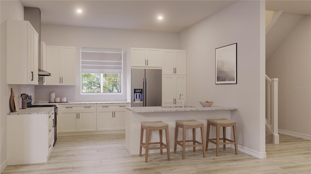 kitchen with light stone countertops, white cabinetry, exhaust hood, and appliances with stainless steel finishes